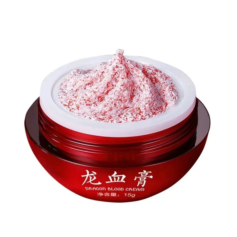 A red cosmetic jar labeled 'DRAGON BLOOD CREAM' with white Chinese characters, shown open with a textured red-and-white cream product piled on top, against a plain white background.