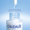 Caudélé skincare dropper bottle with text on a blue background