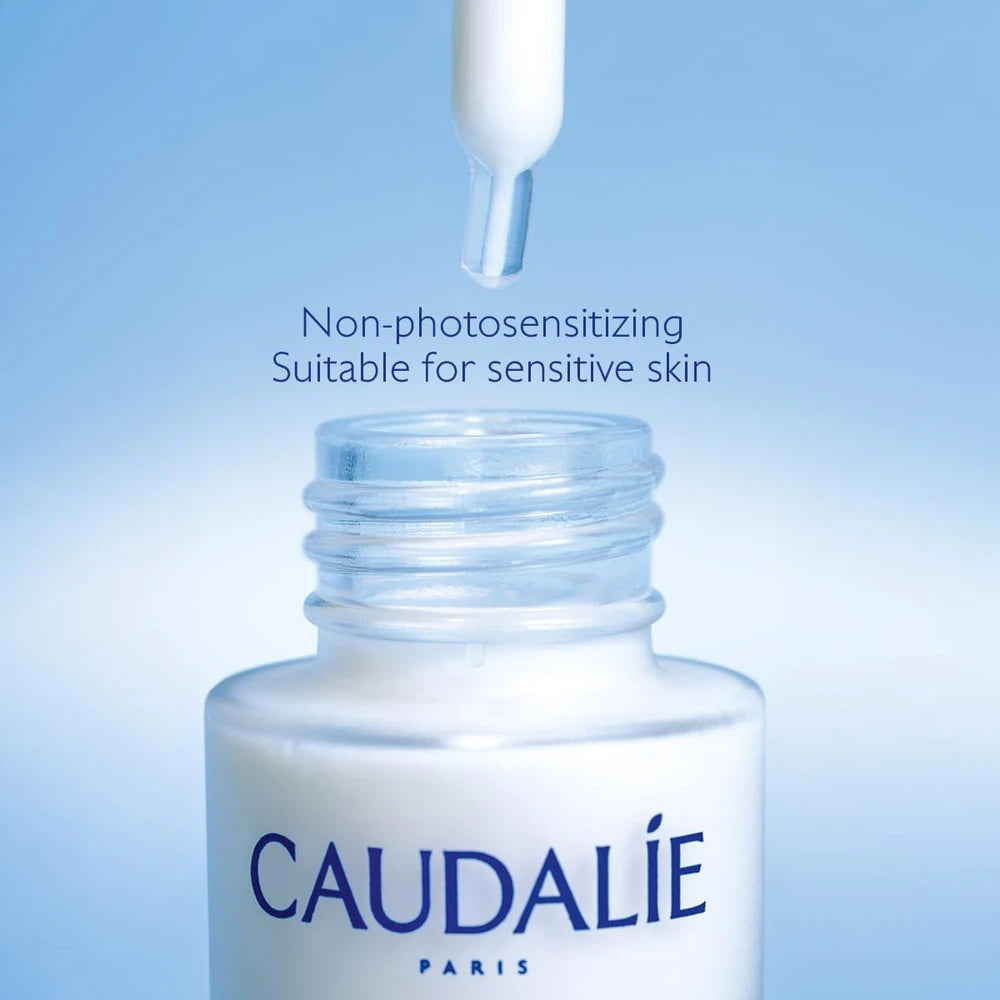 Caudélé skincare dropper bottle with text on a blue background