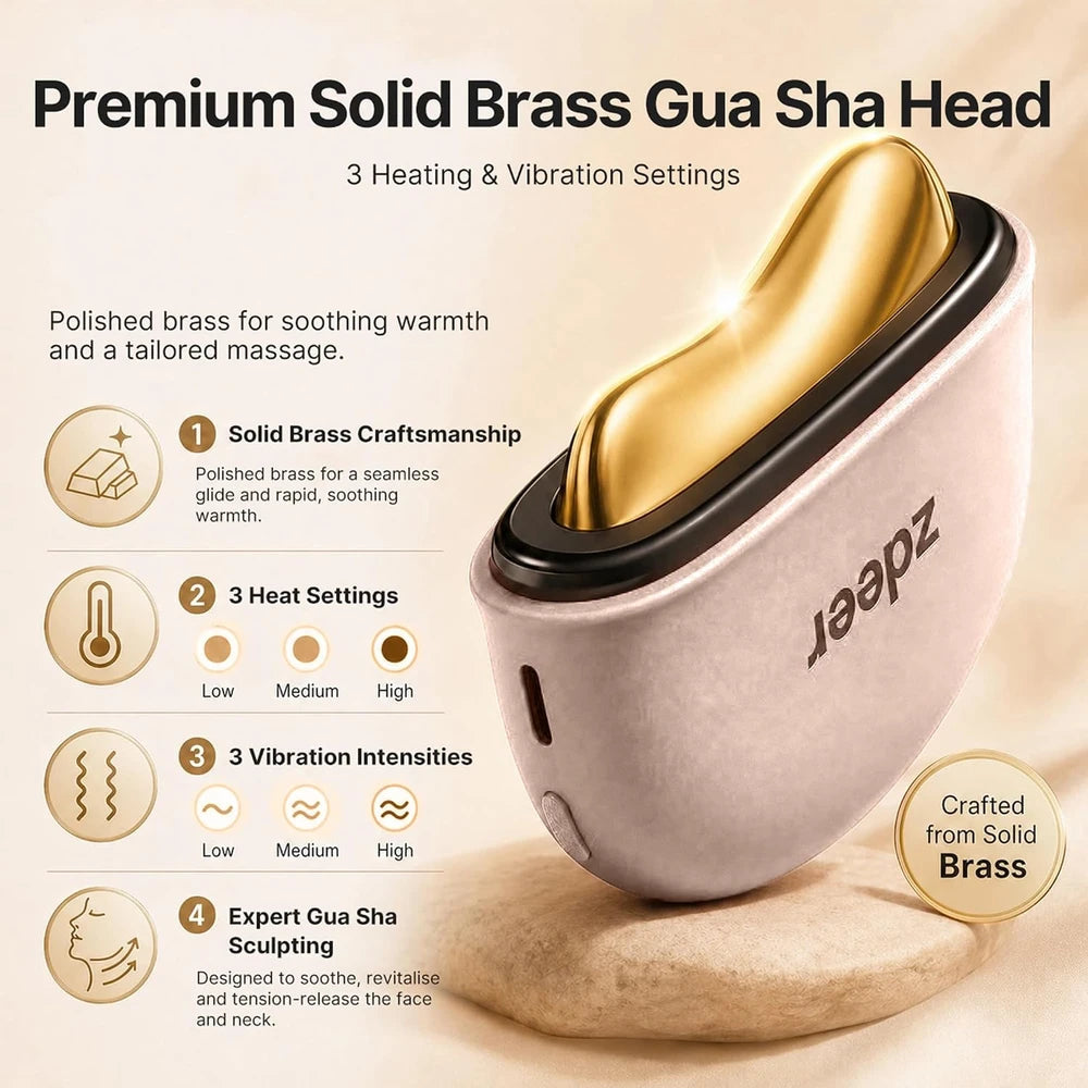 A premium solid brass gua sha head massage tool shown on a beige background with feature callouts. The device has a metallic gold interior and a pale pink exterior with black trim.