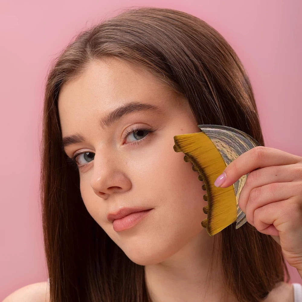 Woman using a brush on her face against a pink background