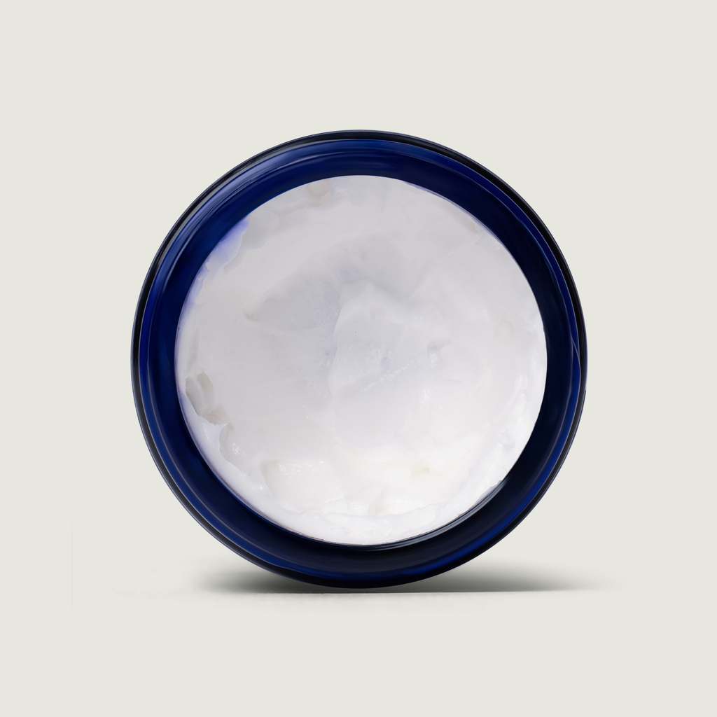 Jar of white cream with a blue lid on a light gray background