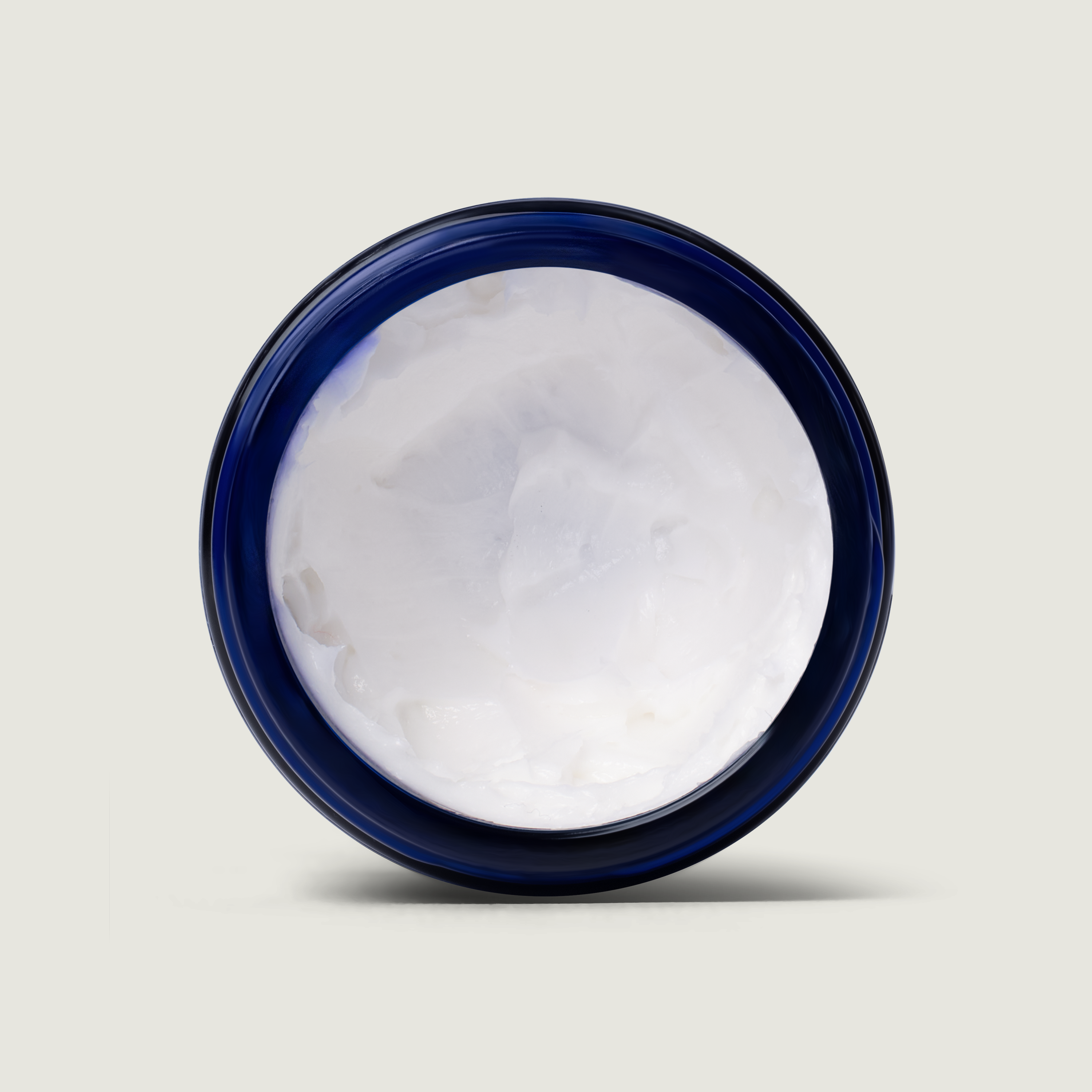 Jar of white cream with a blue lid on a light gray background