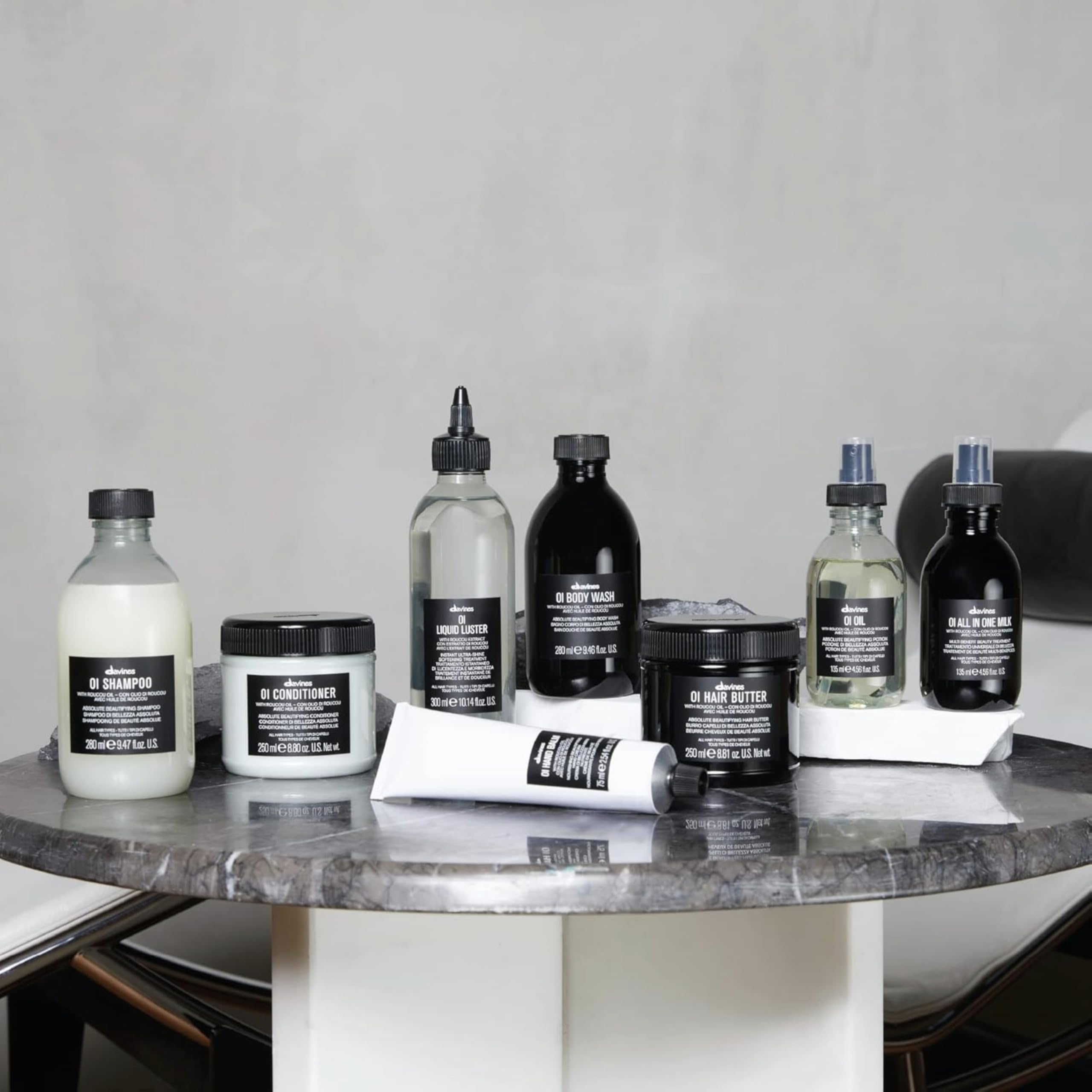 Collection of Aesop skincare and haircare products on a marble surface.