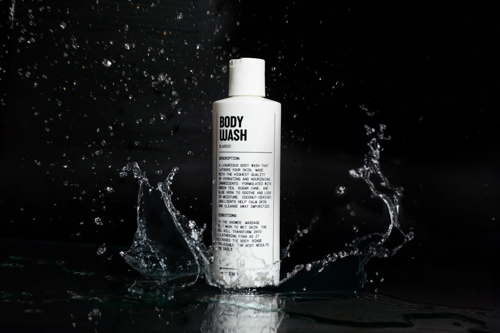 Body wash bottle with water splashes on a black background