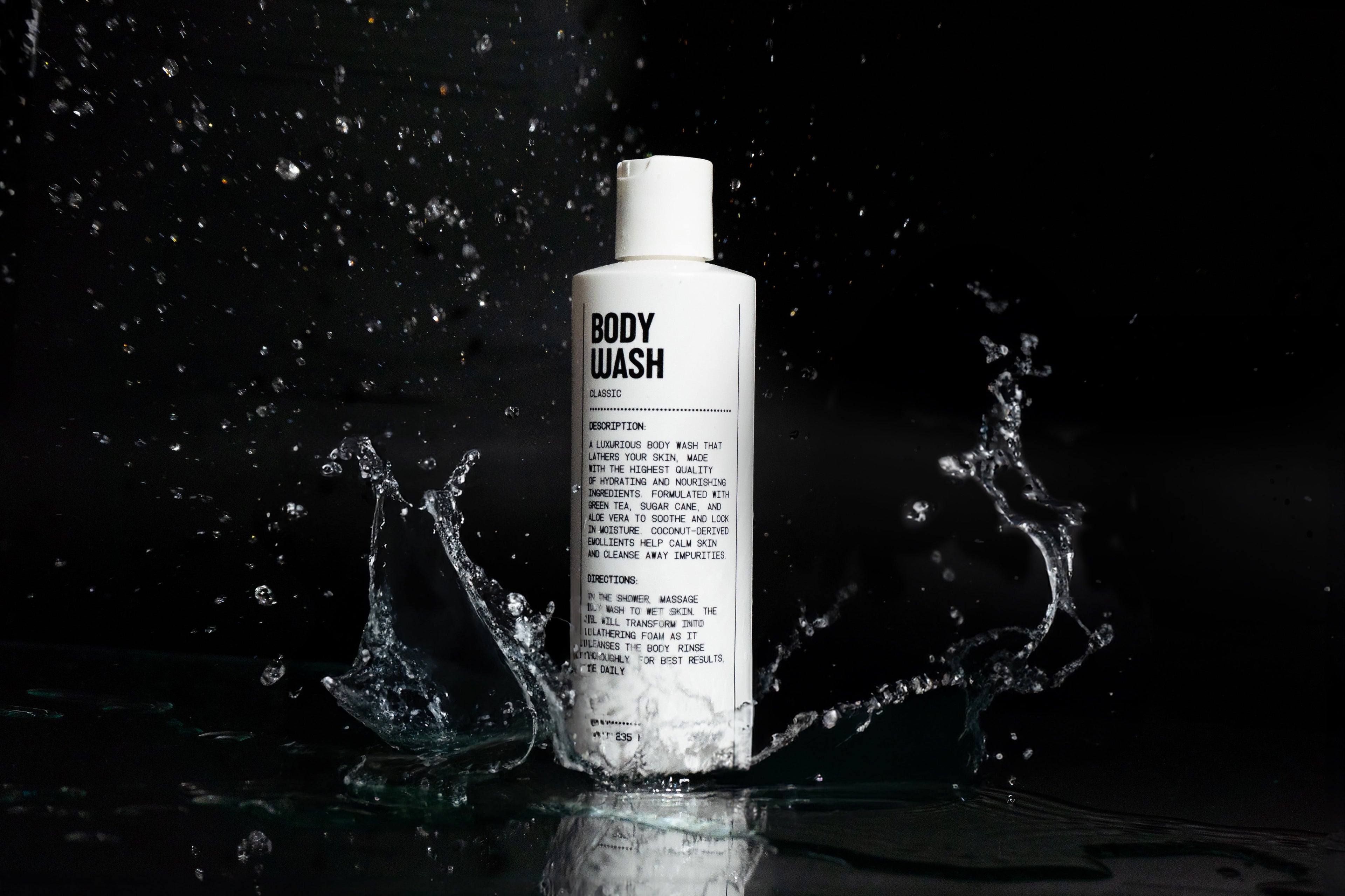 Body wash bottle with water splashes on a black background