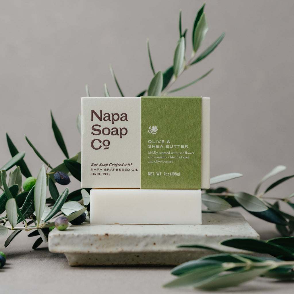 Napa Soap Co. bar soap on a stone surface with greenery in the background