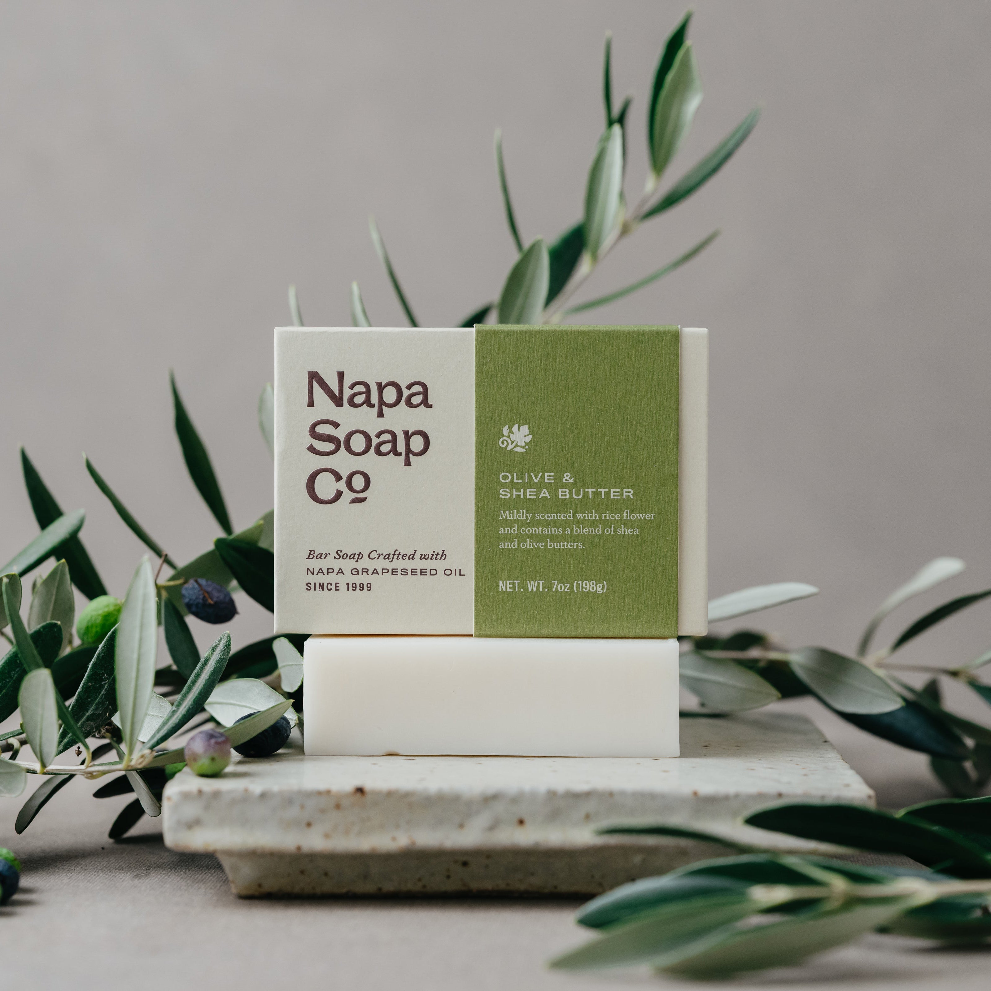 Napa Soap Co. bar soap on a stone surface with greenery in the background