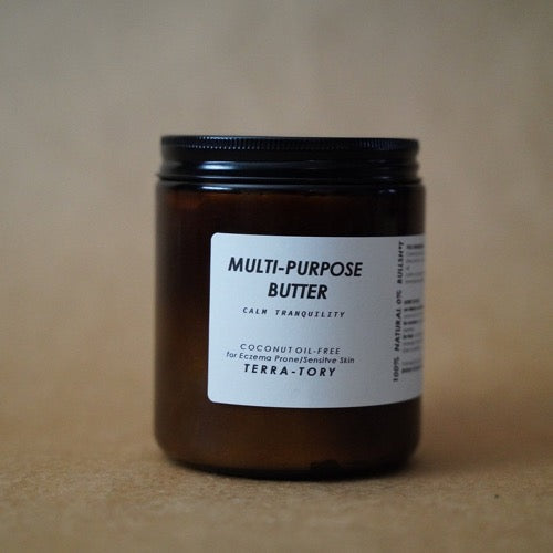 Jar of multi-purpose butter with a label on a brown background