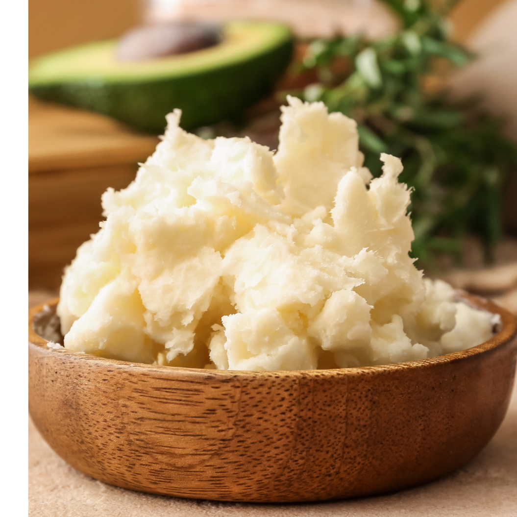 Mashed potatoes in a wooden bowl with an avocado in the background