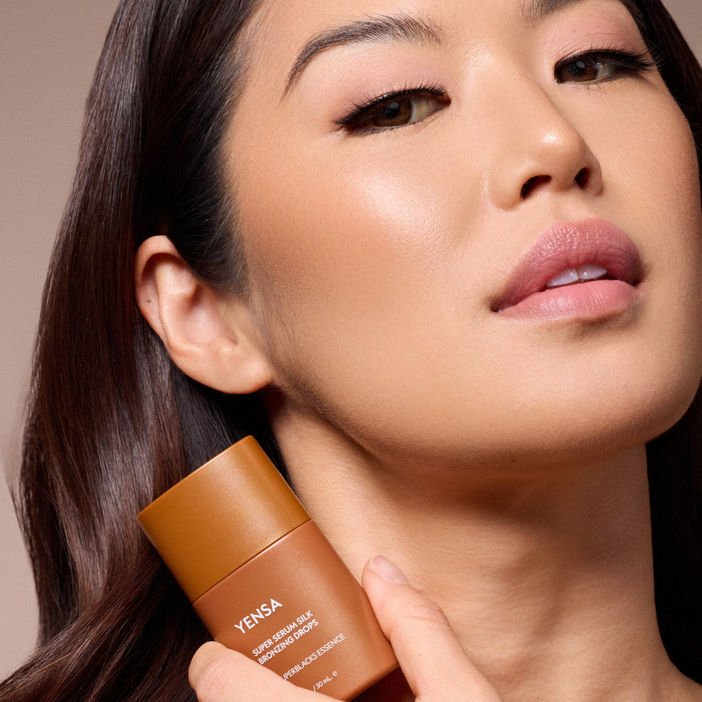Woman holding a YENSA skincare product close to her face