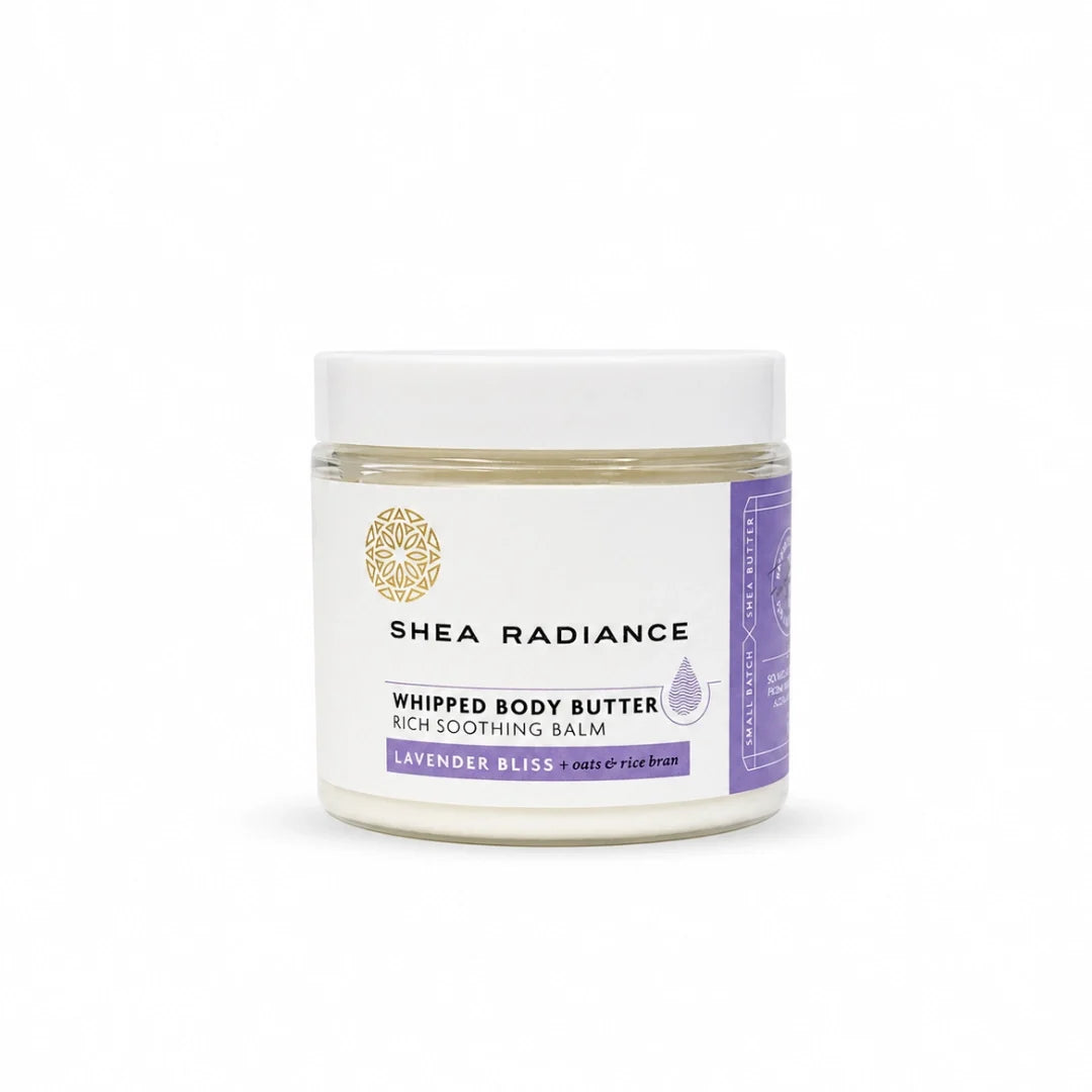 A jar of Shea Radiance Whipped Body Butter in Lavender Bliss, featuring a white lid and a white label with purple and gold accents, set against a plain white background.